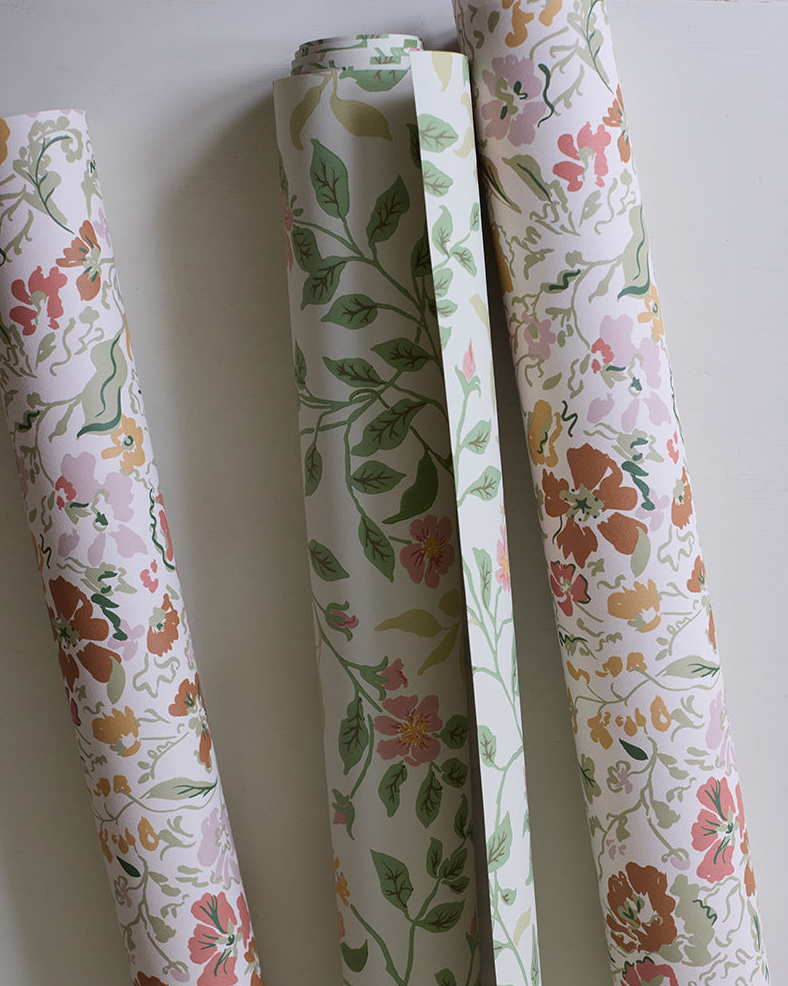 Three rolls of floral-patterned paper against a white background